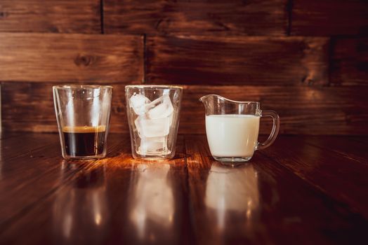 three ingredients for coffee with ice are spread out over cups.