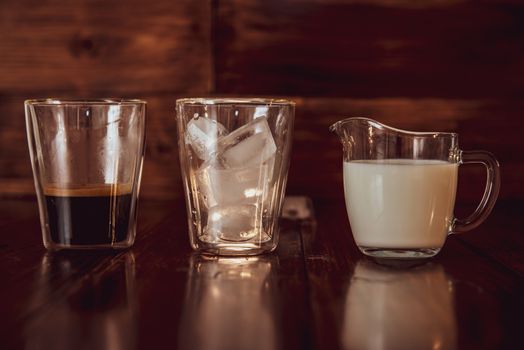 three ingredients for coffee with ice are spread out over cups.