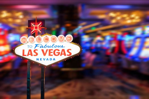 Famous Las Vegas sign at night with casino blur background.