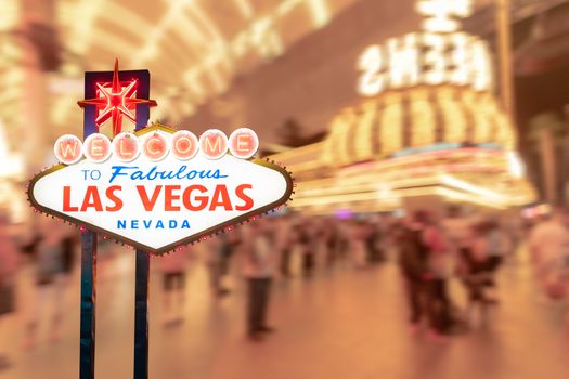 Famous Las Vegas sign at night with Las Vegas Cityscape blur background.