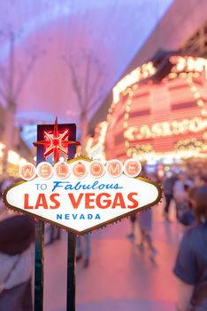 Famous Las Vegas sign at night with Las Vegas Cityscape blur background.