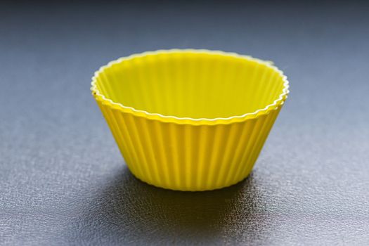Colorful cupcake silicon molds on the blue wood background