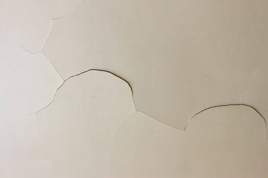Closeup on a crack in a white ceiling of a generic, unidentified old house
