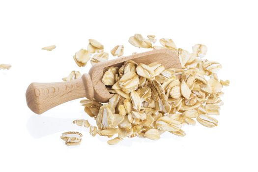 Oat flakes in wooden scoop isolated on white background. Close up.