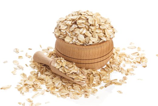 Isolated oatmeal. Oat flakes in wooden bowl on white background