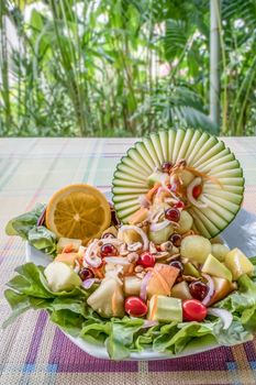 Colorful of fresh fruit salad in melon bowl with spicy sauce