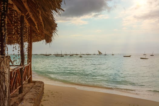 A wonderful beach with Several fishing boats  anchored at sunset with sunbeams.Zanzibar coast,Tanzania.