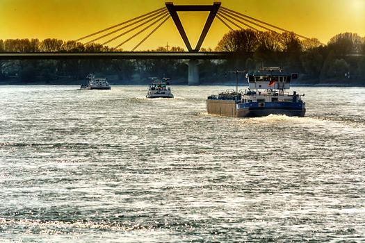 River landscape from the Rhine, near Dusseldorf in Germany. View of the opposite bank and the airport bridge in dramatic sky.