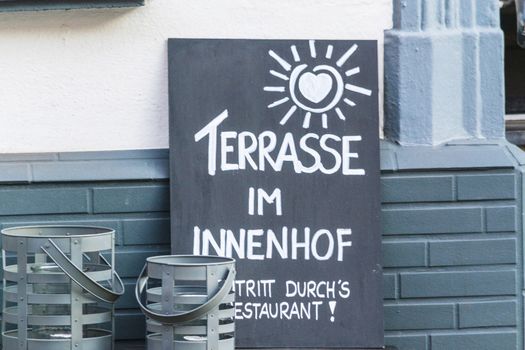 Slate in front of a restaurant with a caption in German "Terrace in the courtyard"