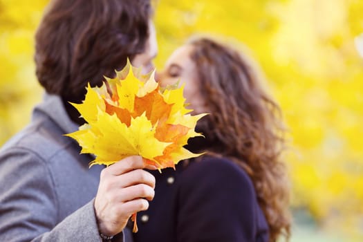 Love, relationship, family and people concept - couple kissing in autumn park