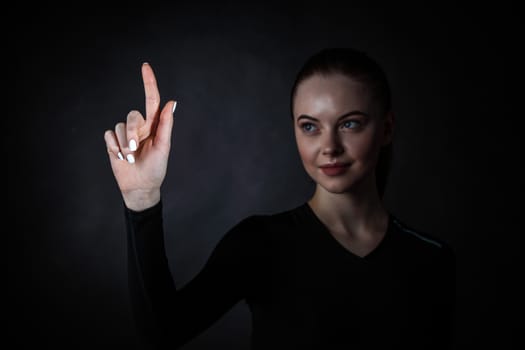 Young woman pointing with finger at virtual display