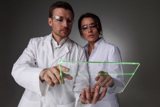 Two scientists or doctors holding blank futuristic transparent digital tablet pc computer with copy space