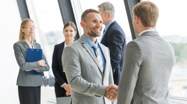 Business people shaking hands, finishing up a meeting in office