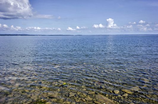 morning on the lake with clear water, you can see the rocky bottom