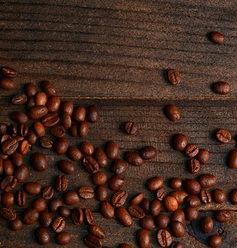 The coffee beans on a wooden background