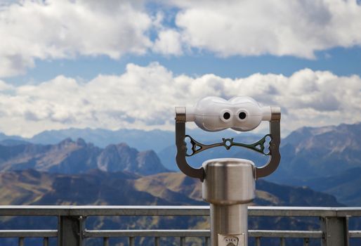 Binocular viewer looking at mountains, in Dolomites, Italy