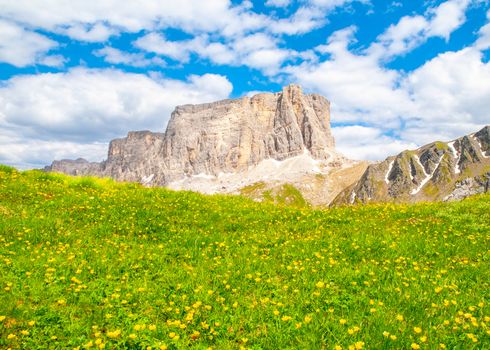 Lastoni de Formin, aka Ponta Lastoi de Formin. Giant mountain block with blooing meadow and summer sky, Dolomites, Italy.