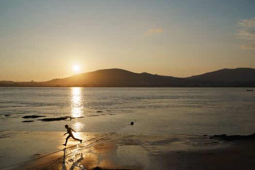 Child running in the last sun rays