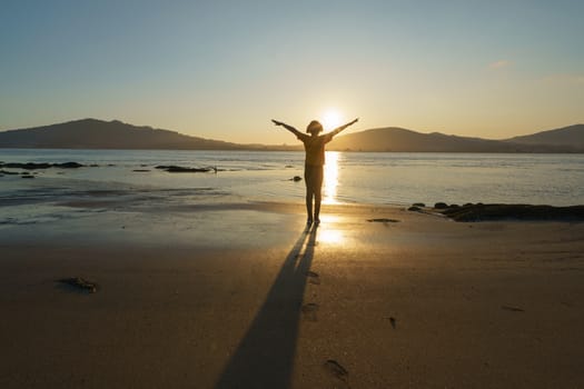 The girl raised her hands in the setting sun