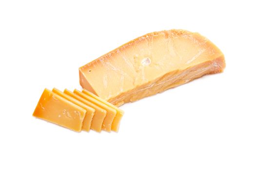 Piece and several slices of the Dutch hard cheese Beemster closeup on a white background
