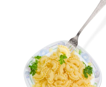 Fragment of the stainless steel fork with some cooked curved and ruffled pasta and the small parsley twig over of a dish with the same pasta on a light background
