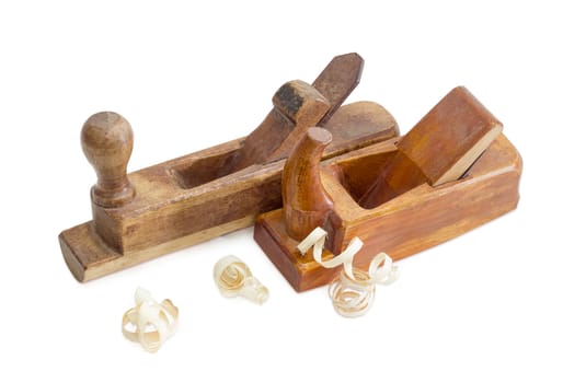 Two old wooden hand planes different purposes and shavings on a white background
