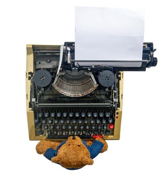 teddy bear on old typewriter from above isolated on white 