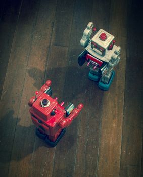 two retro  robots   fight  on a wooden floor shot from above