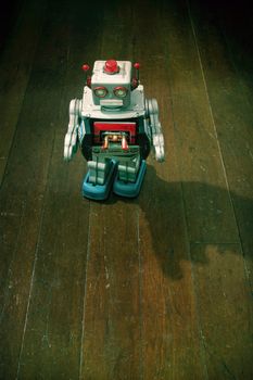 retro silver robot walking on old wooden floor 