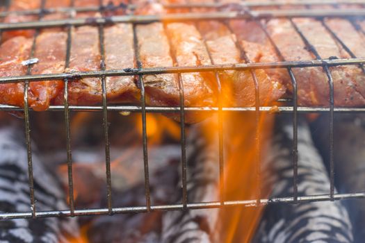 Raw meat steak fry on the grill fire. Barbecue fresh food delicious pork cooking on metal grid