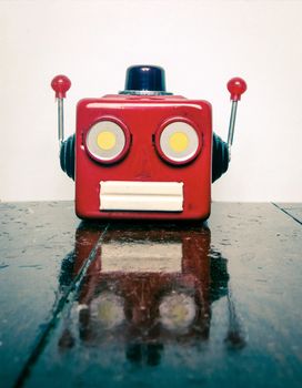 retro tin robot head on wooden floor with reflection