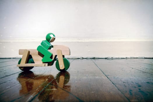 wooden moterbike ona wooden floor with reflection  toned image 