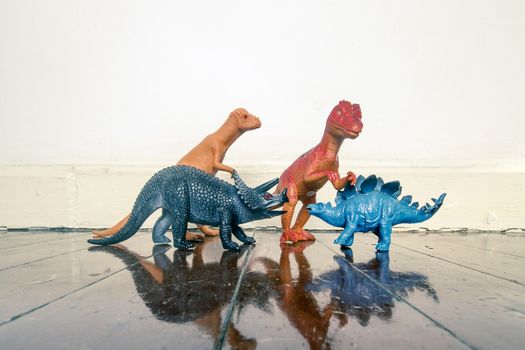 Tyrannosaurus rex and other dinosaurs on a wooden floor with reflection 
