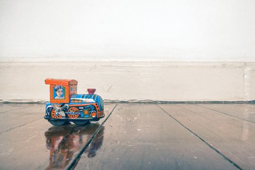 old tin toy train on a wooden floor with reflection 