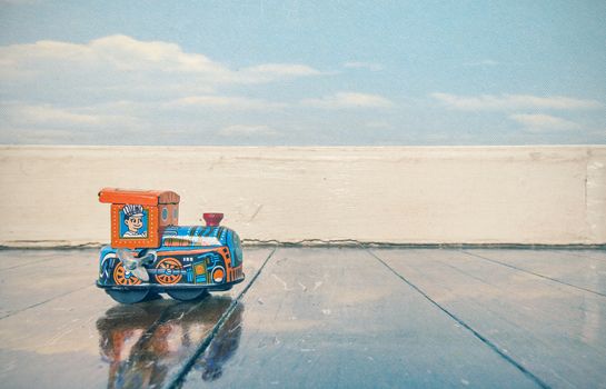 old tin toy train on a wooden floor with reflection 