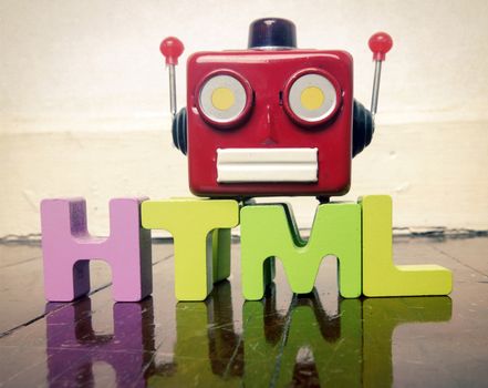 HTML wit wooden letters and a red robot talking head on a wooden floor with reflection 