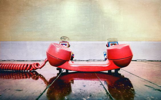 vintabe robots with old  red phone on wooden floor