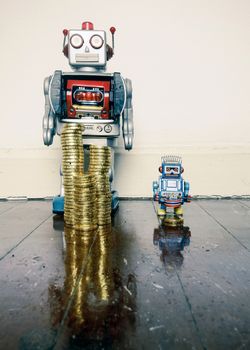 two vintage robots  with gold money on a wooden floor with reflection ,concept inequality,.