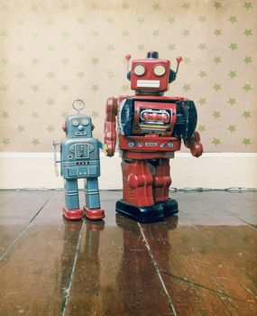 Father and son concept with retro robot toys on an old wooden floor with reflection