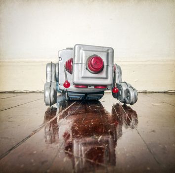 over worked retro silver robot facedown on old wooden floor with reflection
