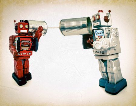 two retro robots talk on tin can phones