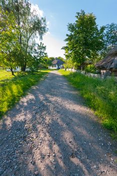 a path on the street of old rural houses with reed roofs. architectural memo
