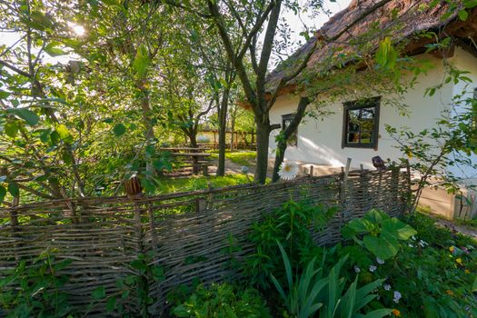 A wicker fence in the garden near the house. Traditional courtyard in the village in the old days.