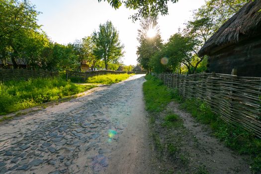 The pavement is laid out on old street with a wicker tin around wooden houses. Uzhhorod Ukraine