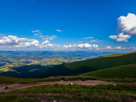 Scenic view from a height to the nearby wide mountain ranges and the blue sky