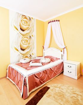 Beautiful classical bedroom interior in yellow colors with fabric pillows
