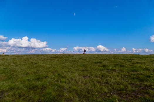 Two Ukrainian tourists against the backdrop of the endless field and the blue cloudy sky