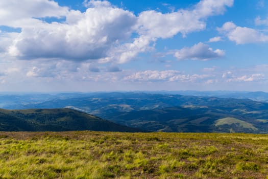 A gorgeous view from the top to a huge green mountain valley in the sun