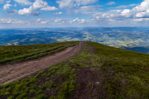 The path leading to the edge of the green mountain, from which a beautiful scenic landscape opens up