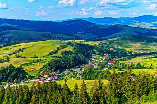 bright red roofs of houses spread out among the green hills in the Carpathian city